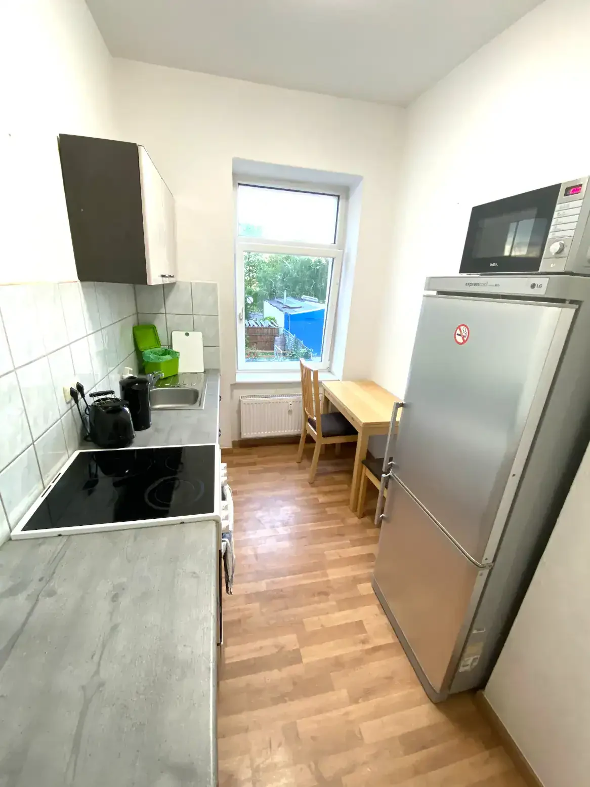 Moderne Küche im Apartment Leipzig Südwest mit Kühlschrank, Kochfeld und Essplatz